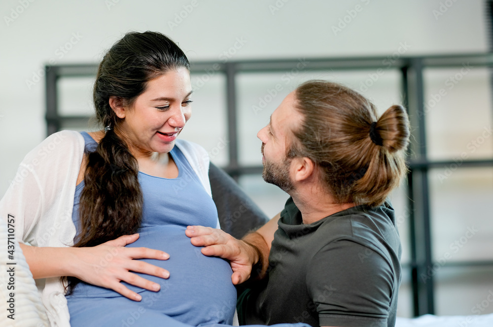 Pregnant woman lie on bed to relax and look at her husband with love and happy emotion. Concept of happy family or parent stay at home together. Pregnant woman lie on bed to relax and look at her husband with love and happy emotion. Concept of happy family or parent stay at home together.