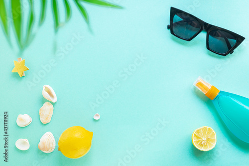 Summer background vacation beach mood tropical leaf travel accessories ocean sea, summer sunscreen bottle of lotion, sun glasses, seashells, lemon top view