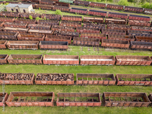 Freight trains on railway tracks. Aerial drone top view. Sunny spring day.