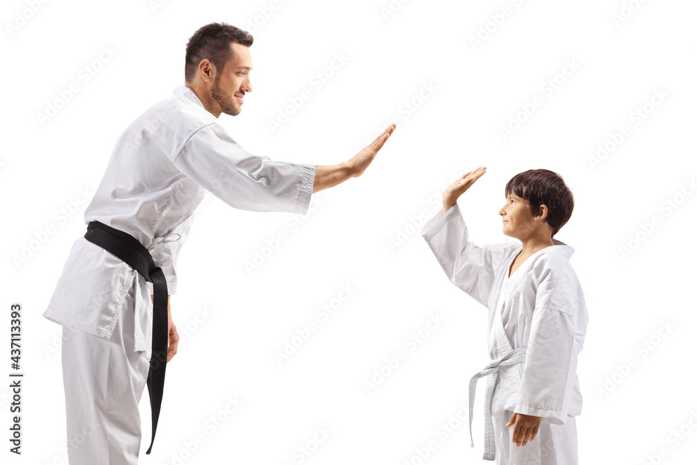 Child and man in karate kimonos gesturing high-five Child and man in karate kimonos gesturing high-five