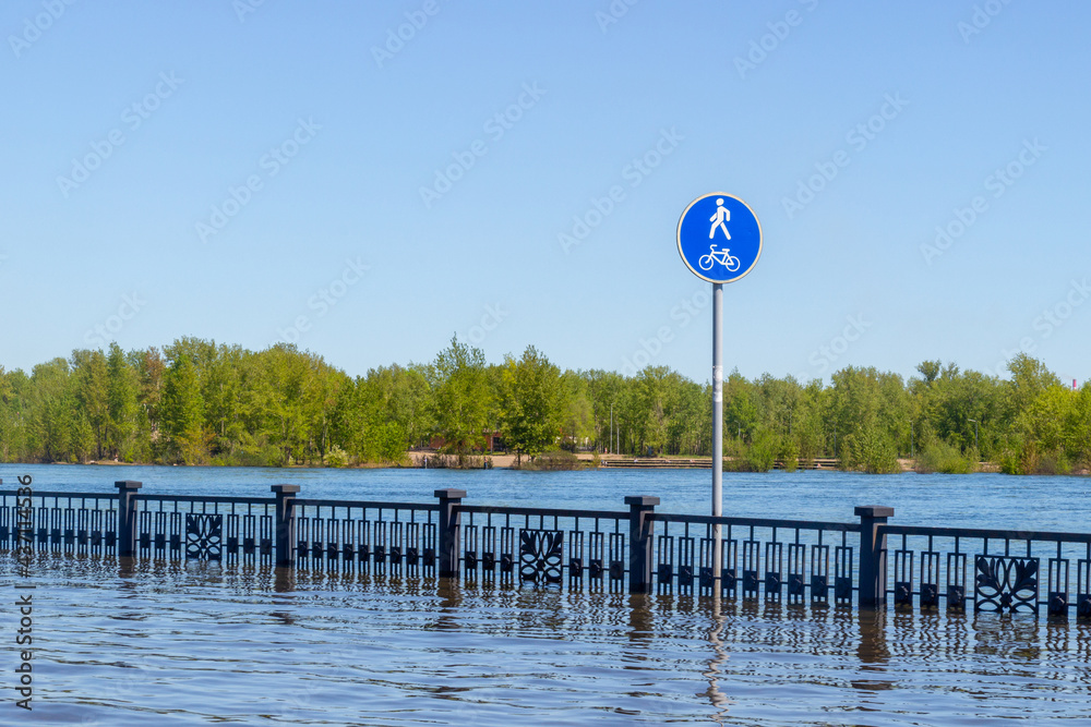 Flooded city embankment in Krasnoyarsk, Russia. Flooding of Yenisei River in spring during melting of snow and water discharge from the Krasnoyarsk Dam. Natural disaster