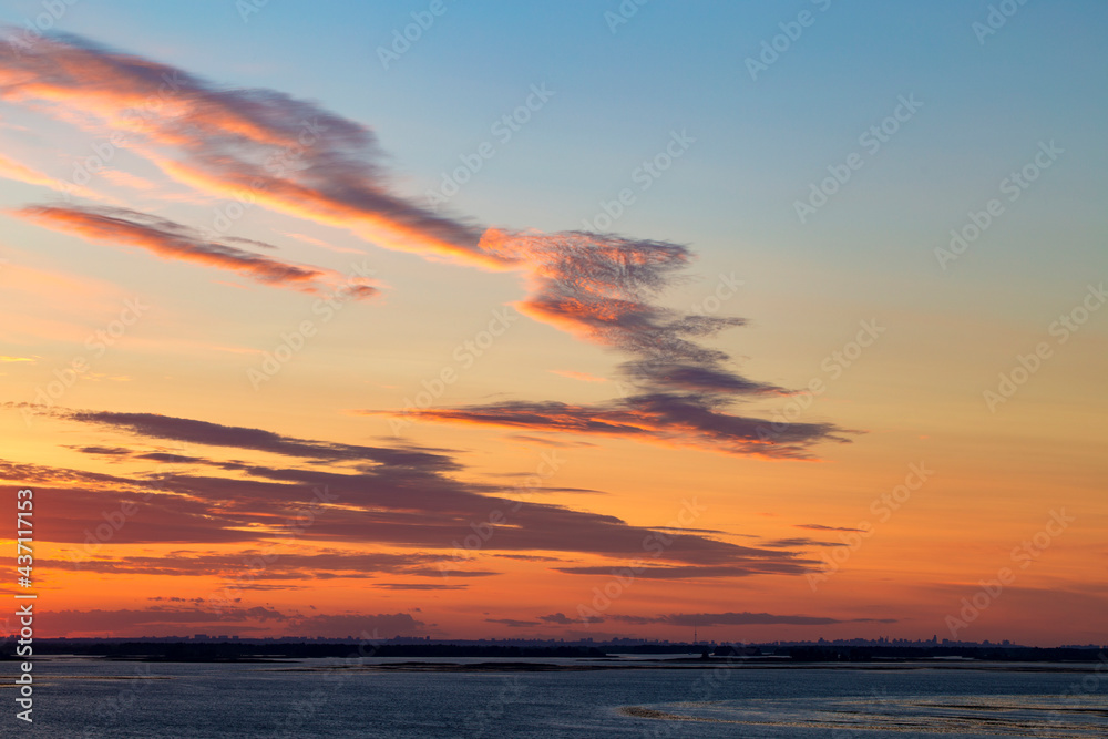 Sunset on the river. Colorful landscape with river and blue sky with multicolored clouds. River sunset panorama