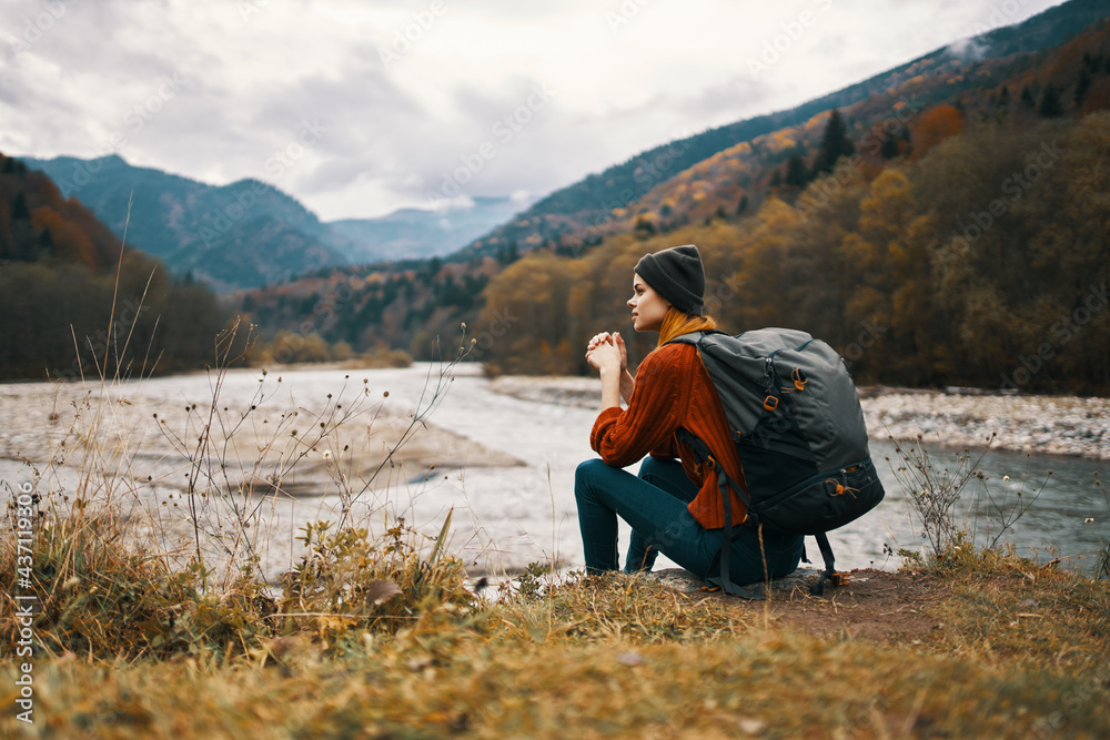 Fototapeta premium woman travels in the mountains near the river in the meadow in the forest rest relax