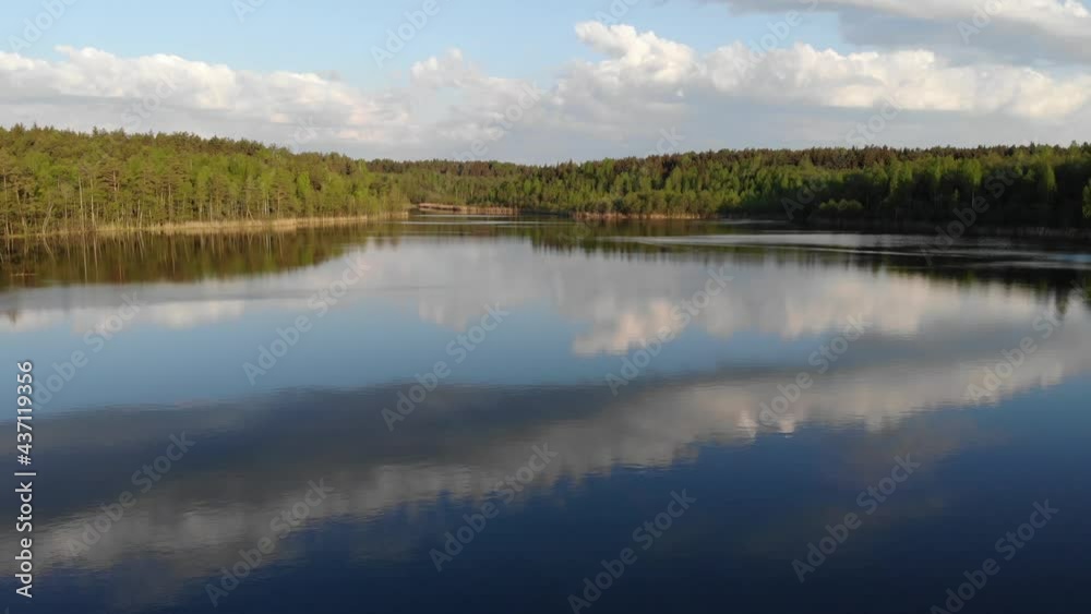 Lake and forest in spring sunrise light 4k aerial top view. Fly above water of lake Dolgoe, Belarus. Drone aerial video Lake and forest in spring sunrise light 4k aerial top view. Fly above water of lake Dolgoe, Belarus. Drone aerial video