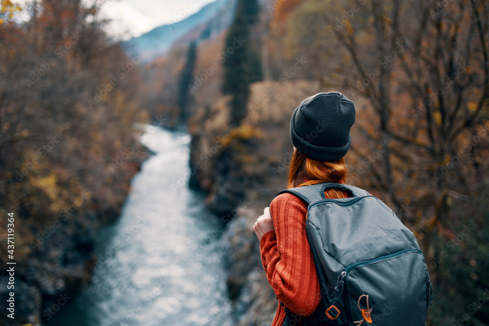 woman with backpack admires the river in the mountains nature travel woman with backpack admires the river in the mountains nature travel