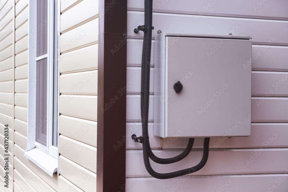 Electrical panel with electric wires in it on a wall outside the house. Electrical panel with electric wires in it on a wall outside the house.