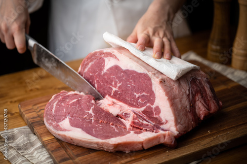 chef cutting block of ribeye beef steak