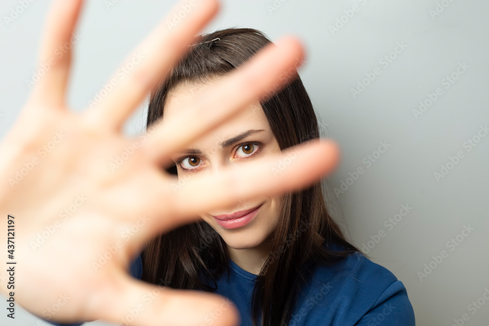 Pretty young woman covers her face with her hand. Pretty young woman covers her face with her hand.