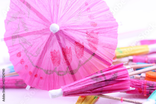 Umbrella for cocktail of pink color a close up. A background with the opened paper umbrella horizontally.