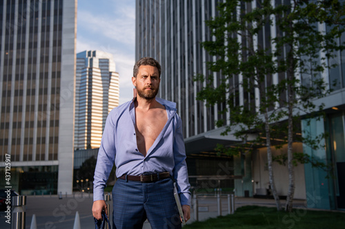 Portrait of sexy businessman standing in a office.