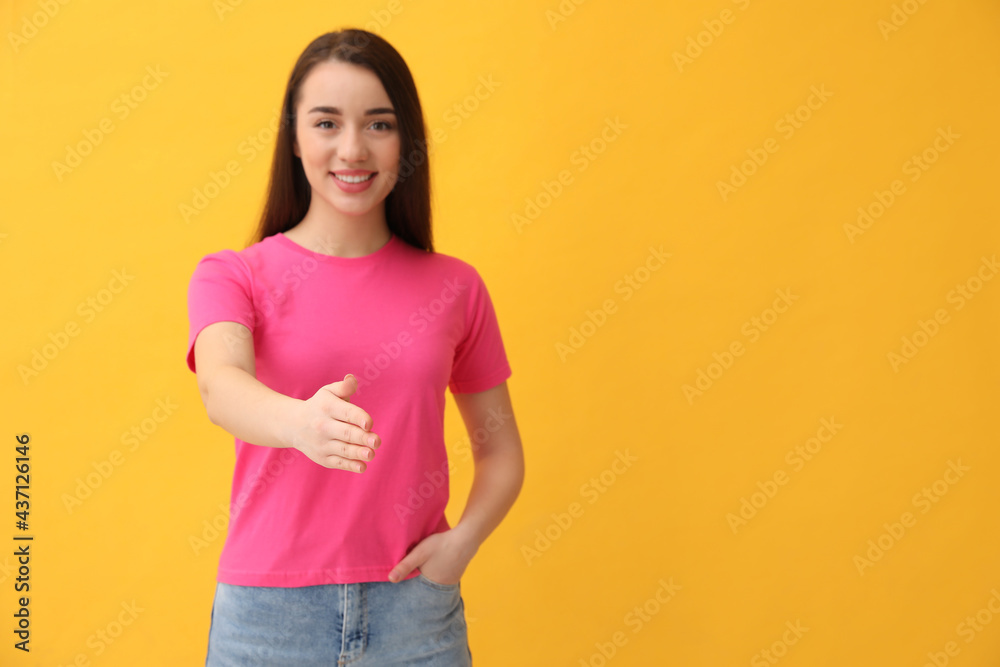 Happy young woman offering handshake against yellow background, focus on hand. Space for text Happy young woman offering handshake against yellow background, focus on hand. Space for text