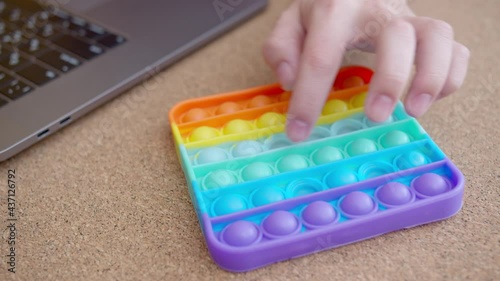 Woman plays with colored silicone antistress toy pop it