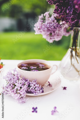 Still life with lilac flowers and cup of tea