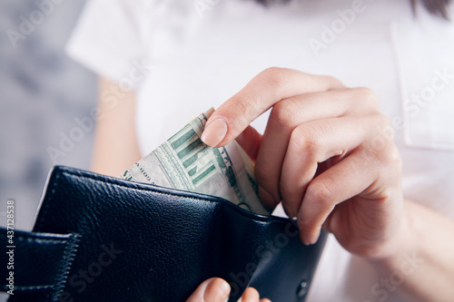 girl holds wallet in her hands and takes money