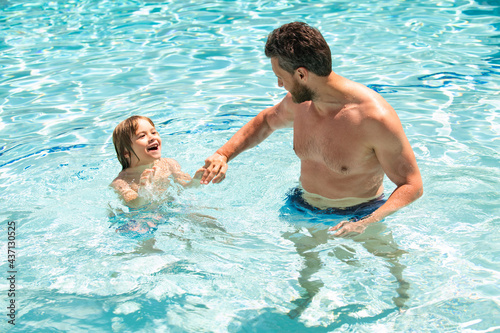 Father and son swimming in pool. Summer family leisure. Dad and son on swimming lessons. Summertime holidays.