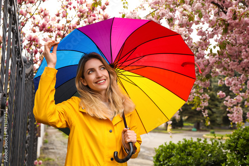 Young woman with umbrella in park on spring day