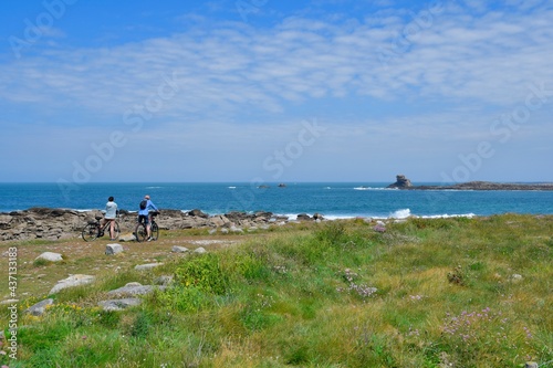 People in bike in front of the sea at "ile Grande" in Brittany. France