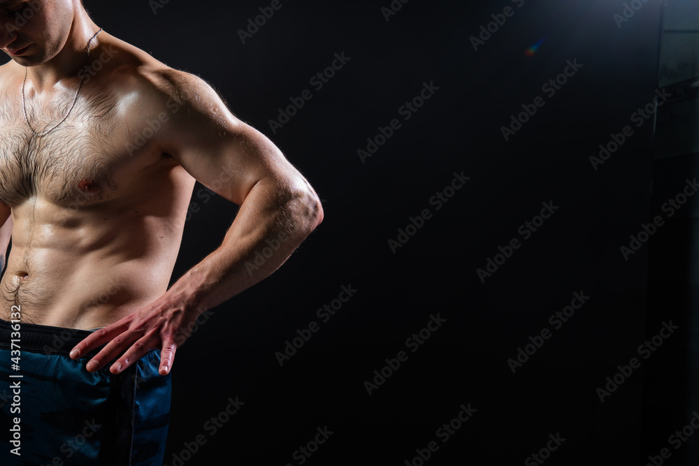Man on black background keeps dumbbells pumped up in fitness muscle chest black, body weight weightlifting. sportive one fit Look at the press and measures the size of pants for weight loss, lovely Man on black background keeps dumbbells pumped up in fitness muscle chest black, body weight weightlifting. sportive one fit Look at the press and measures the size of pants for weight loss, lovely