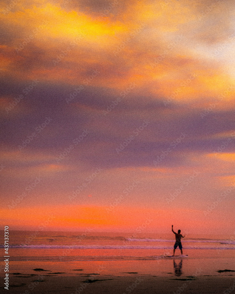 person walking on the beach at sunset