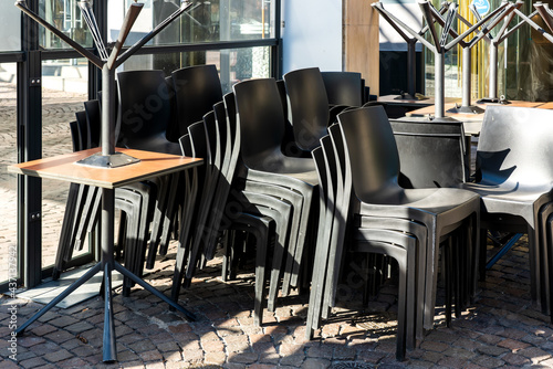 Fototapeta Naklejka Na Ścianę i Meble -  Stacked chairs and tables in a restaurant which is closed due to a corona virus