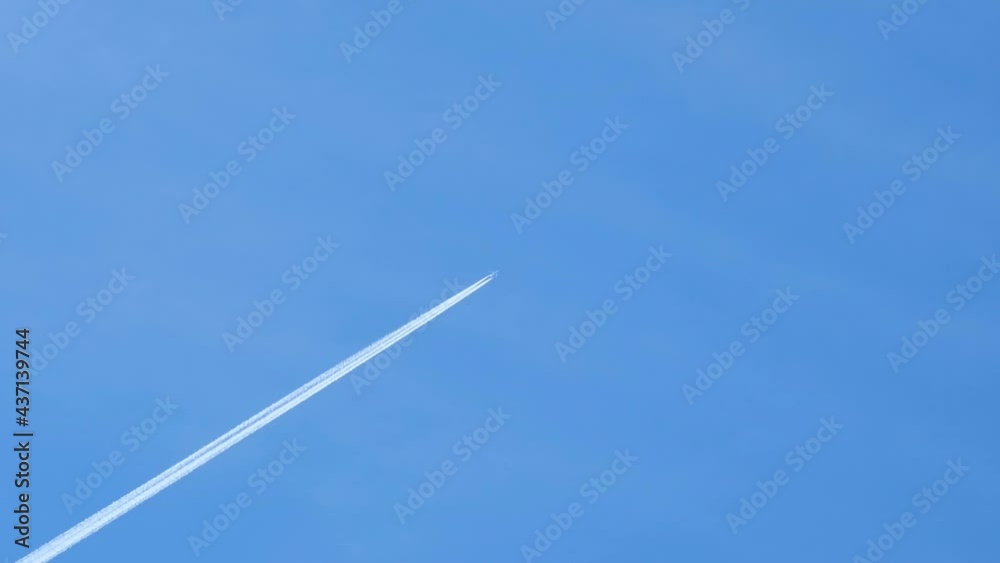 Commercial Airplane flying on deep blue sky with chemical direction trails,aerial tourism transportation Commercial Airplane flying on deep blue sky with chemical direction trails,aerial tourism transportation