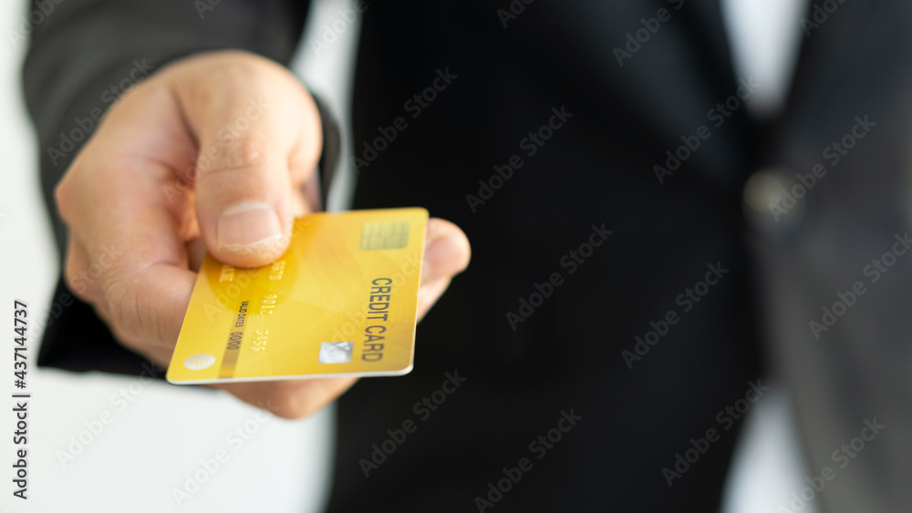 Credit card in hand with phone and laptop to shop online. Credit card in hand with phone and laptop to shop online.