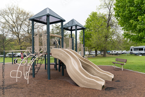 Canvas Print Children playground in public park surrounded by green trees