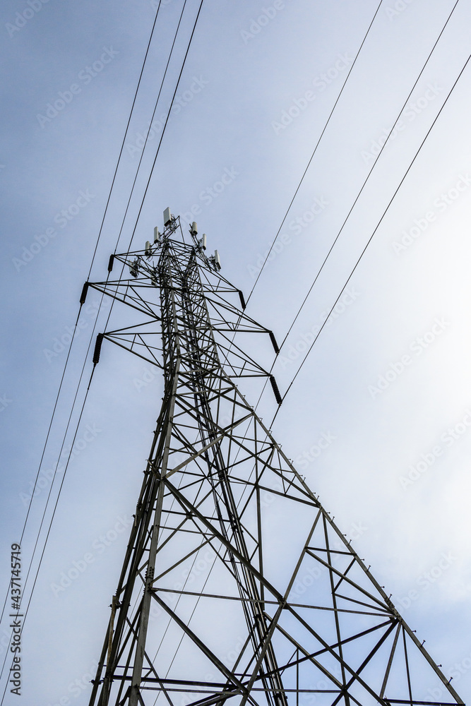 Tall lattice tower supporting power lines and mobile antennas, from a low perspective
Tall lattice tower supporting power lines and mobile antennas, from a low perspective