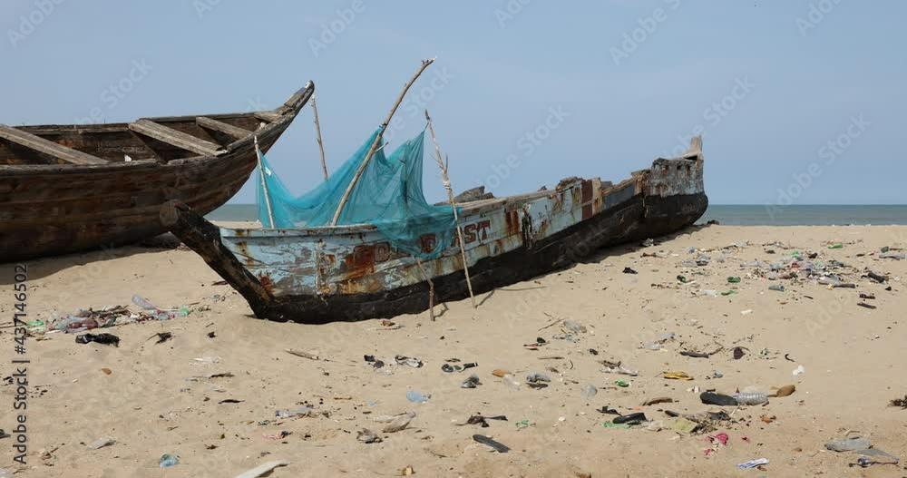 Traditional fishing boat sandy beach Ghana Africa. Old handmade fishing boats fish together at night for the local village. Poor sanitation and neighborhoods. Traditional fishing boat sandy beach Ghana Africa. Old handmade fishing boats fish together at night for the local village. Poor sanitation and neighborhoods.