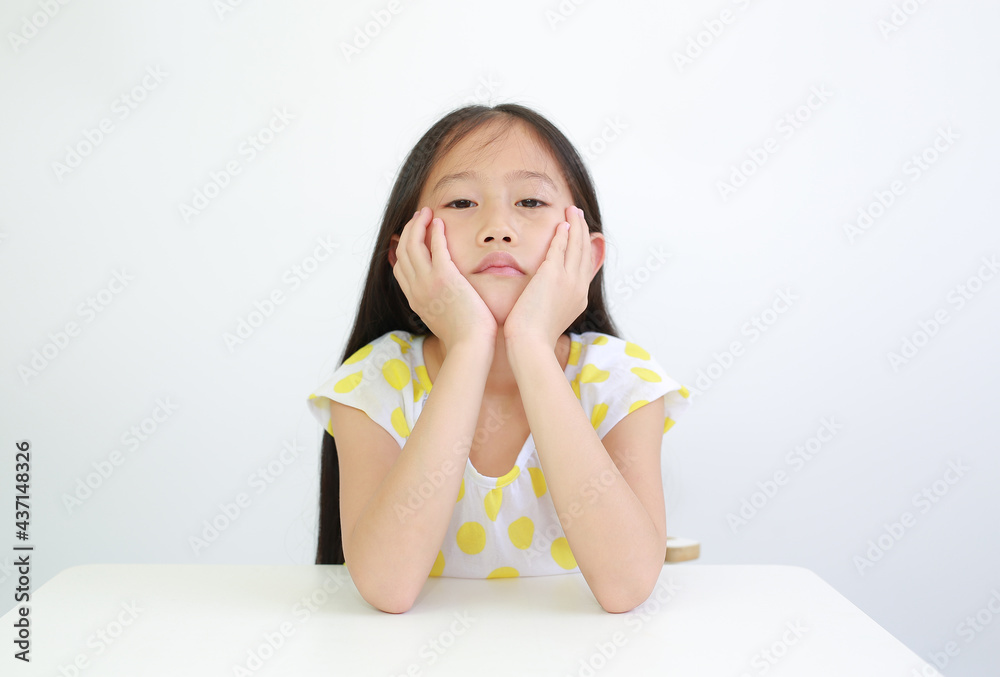Serious Asian little child girl resting chin on hands with looking