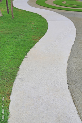 Cement path walkway with green grass beside in the garden