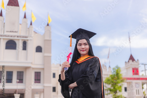 Female graduates happily celebrate university graduation with diploma