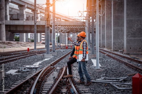 Engineer under discussion inspection and checking construction process railway switch and checking work on railroad station .Engineer wearing safety uniform and safety helmet in work.