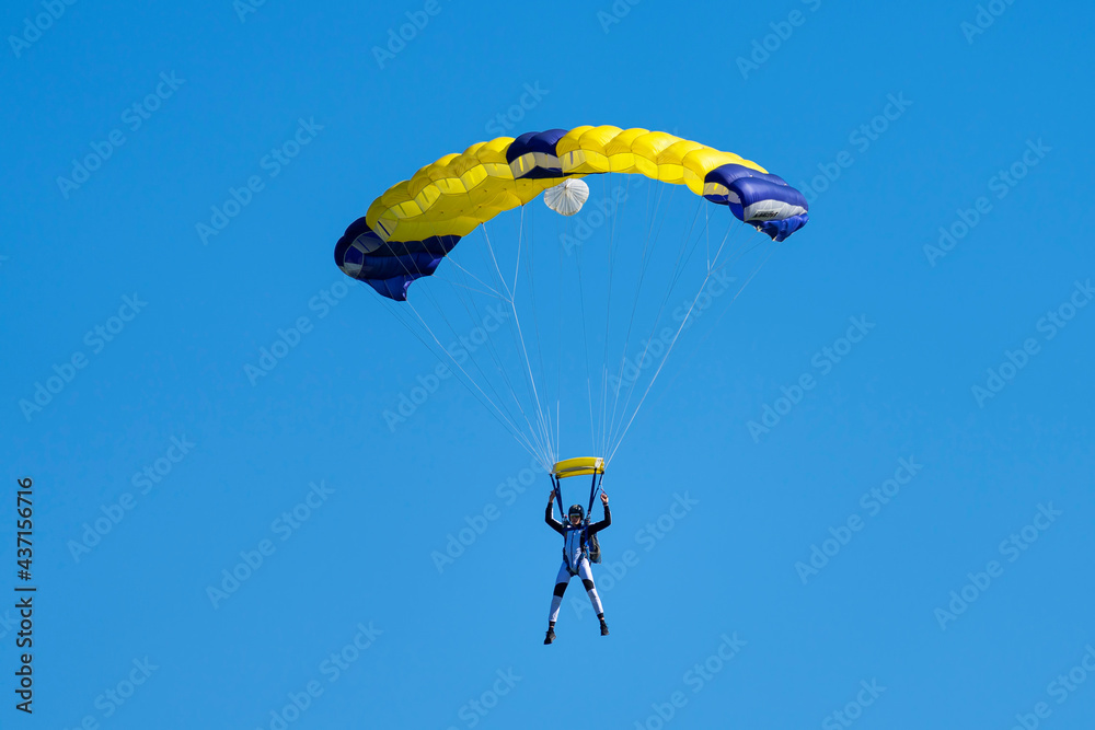 Parachutist with yellow and blue parachute Parachutist with yellow and blue parachute