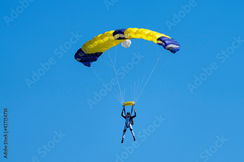 Parachutist with yellow and blue parachute