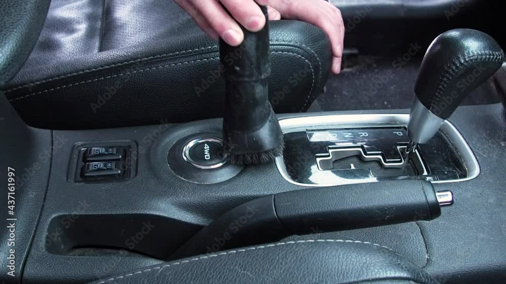 Man dry cleaning dirty car interior with vacuum cleaner Man dry cleaning dirty car interior with vacuum cleaner