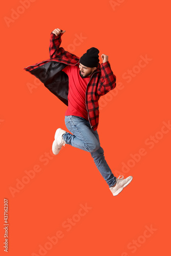 Jumping young man on color ...