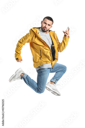 Jumping young man with mobi...