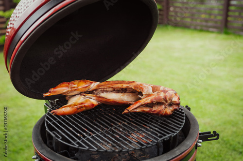 Red Ceramic Barbecue Grill in homes terrace. Gourmet barbecue - rabbit grilling, smoking, baking, BBQ and roasting process. Healthy lifestyle concept.
