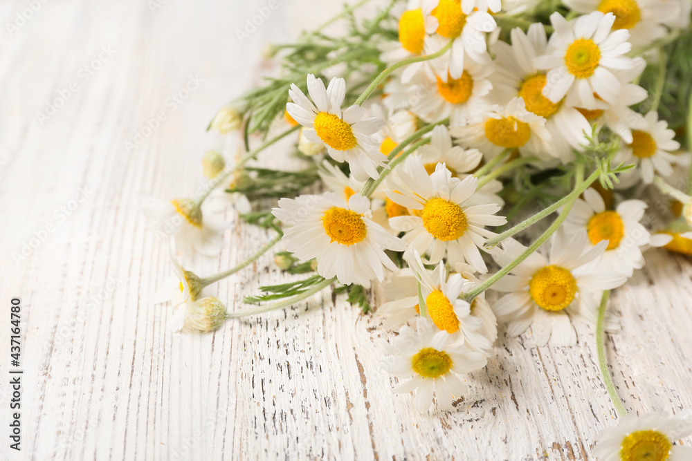 Obraz premium Bouquet of beautiful chamomile flowers on light wooden background, closeup