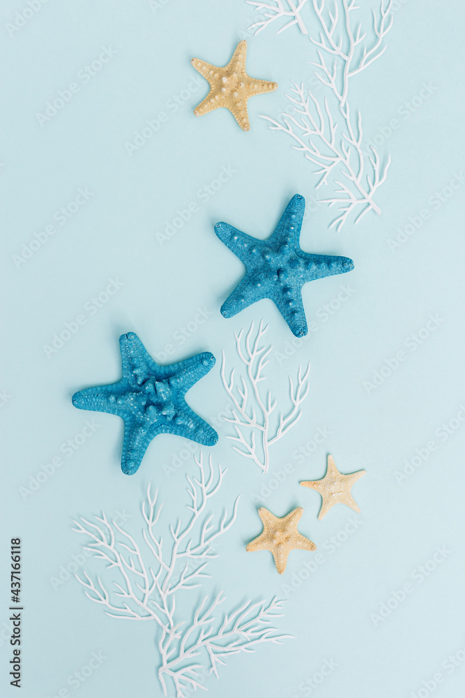 Summer flat lay with sea star and coral on blue background. Summer time rest concept Summer flat lay with sea star and coral on blue background. Summer time rest concept