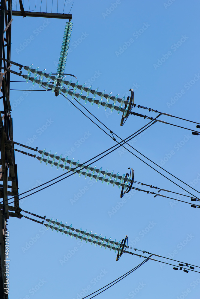 power line of cables and insulators close up. electrical insulators support cables placed on bracket installed on power pole. Clear blue sky without cloud background. Concept of industrial power line of cables and insulators close up. electrical insulators support cables placed on bracket installed on power pole. Clear blue sky without cloud background. Concept of industrial