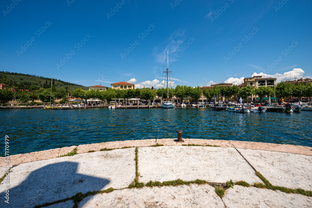 The small port of Garda town with small boats moored, tourist resort on the coast of Lake Garda (Lago di Garda). Verona province, Veneto, Italy, southern Europe.
