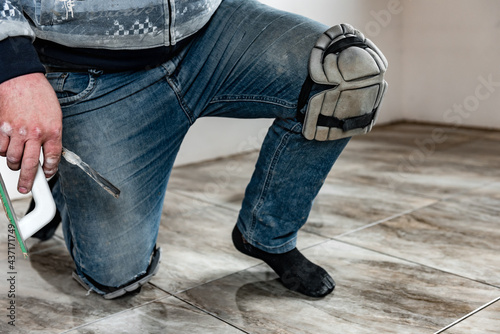 Builder wearing knee protection pads to work in a construction. Safety at work. photo