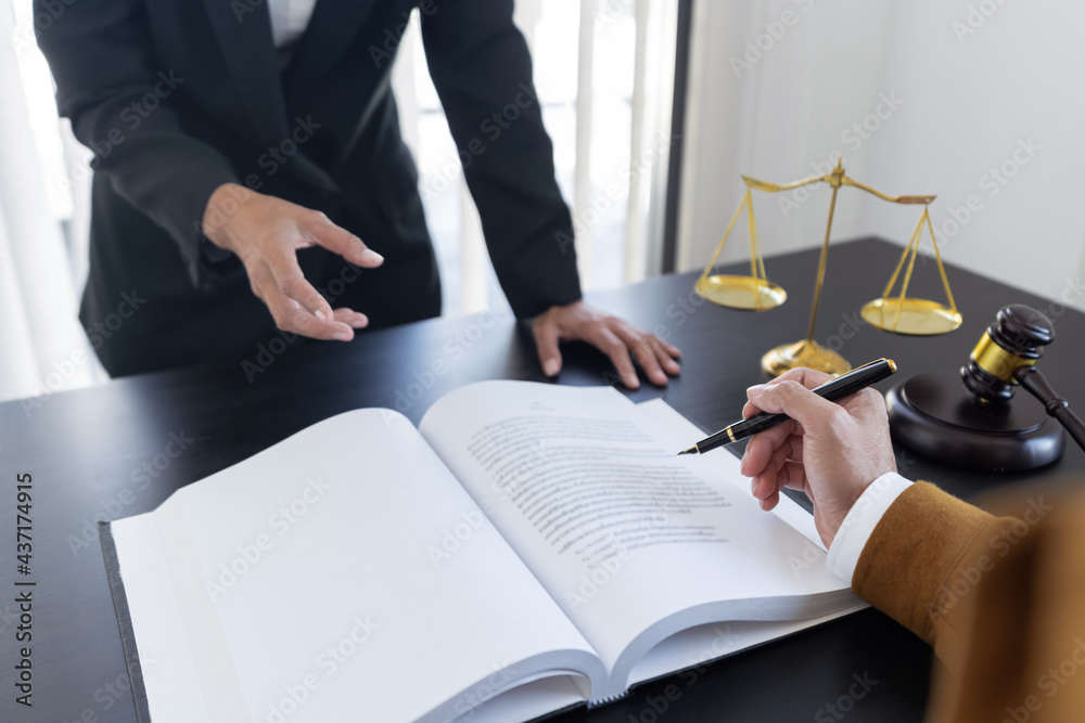 law,libra scale and hammer on the table, 2 lawyers are discussing about contract paper, law matters determination.pointing pen law,libra scale and hammer on the table, 2 lawyers are discussing about contract paper, law matters determination.pointing pen