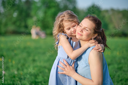 nature scene with family outdoor lifestyle. Mother and little daughter playing together in a park. Happy family concept. Happiness and harmony in family life.