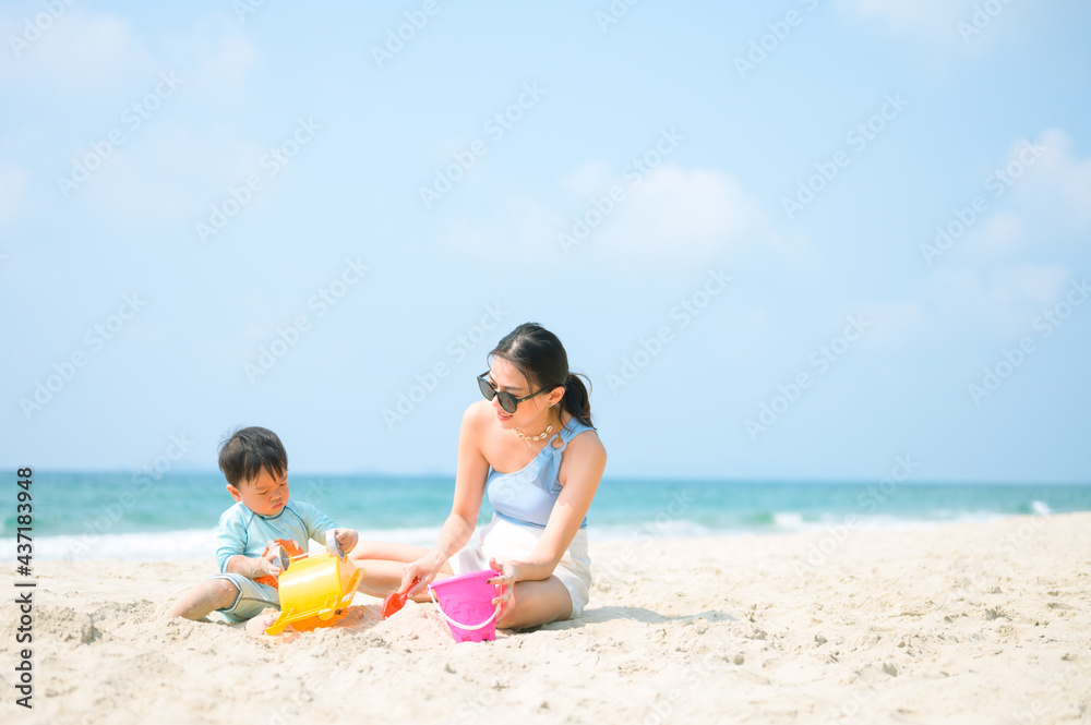 Happy family resting at beach in summer, Mother and baby feet at the sea foam at the sunlight water is moving