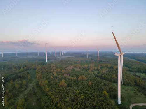 Wind turbines on sunset at summer evening. Renewable energy