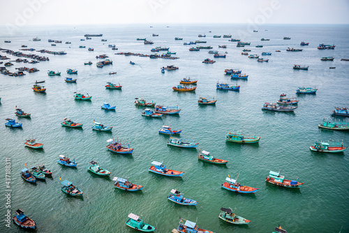 Many fishing boats anchored in the sea waiting for the right tide to go out to the ocean to fish.