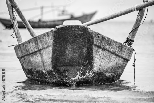 Rowing boat anchored to the shoreline with oars.